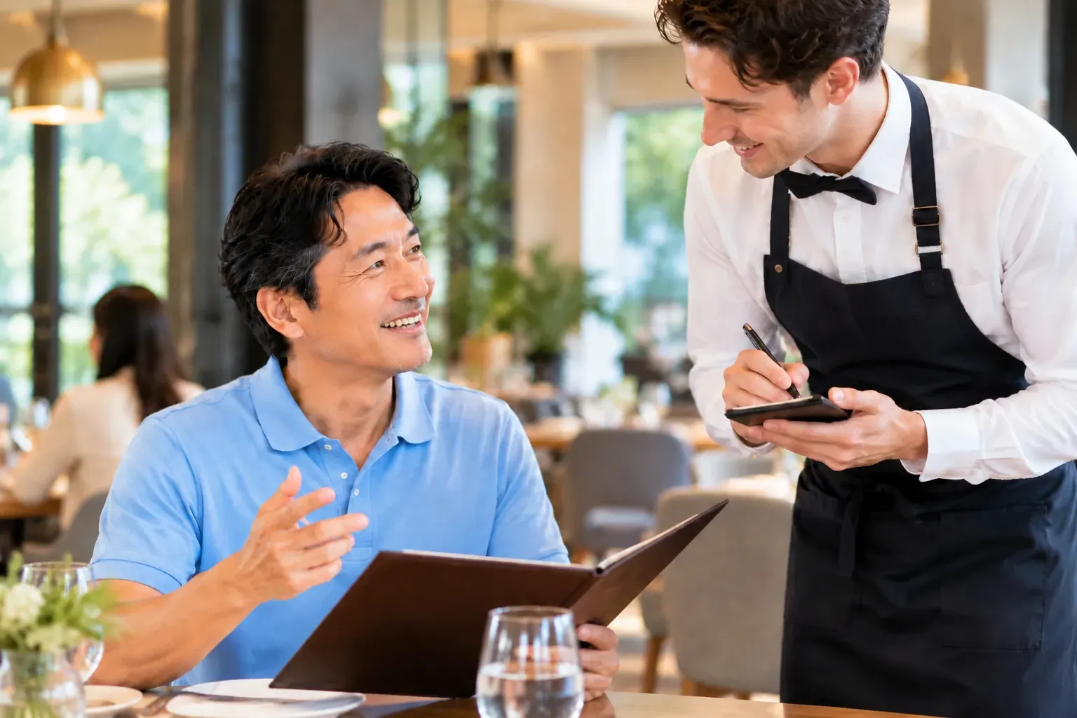 レストランで店員と英語で会話する男性